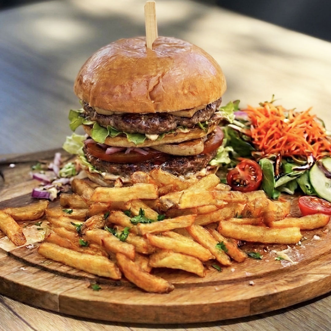 Vue sur le Burger Rossini du Yacht Café, restaurant Carnon, avec steak haché, foie gras, tomates, oignons et salades.