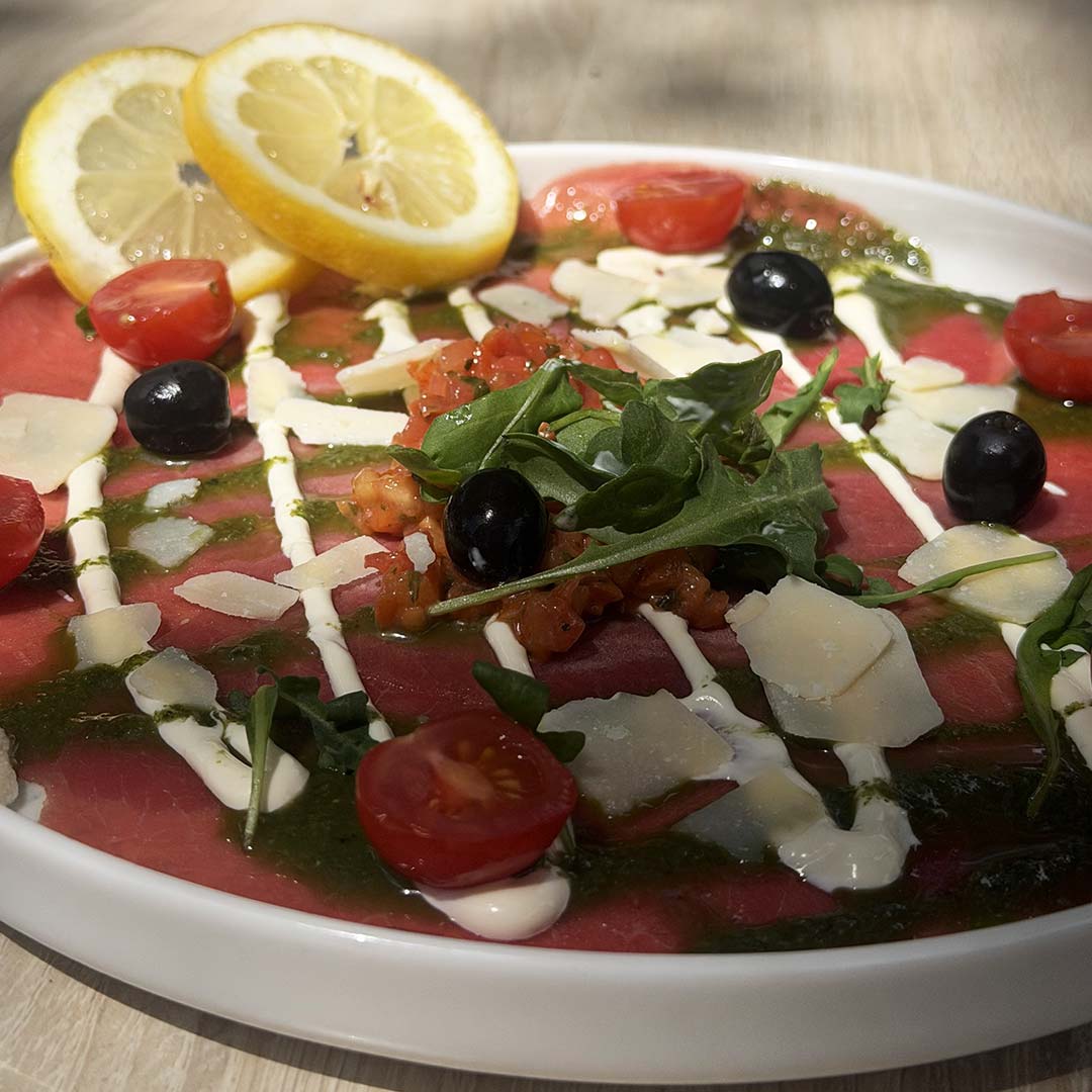 Vue sur le plat "Carpaccio de Bœuf" avec parmesan, olives et tomates, le Yacht Café, menu moule frite Carnon disponible.