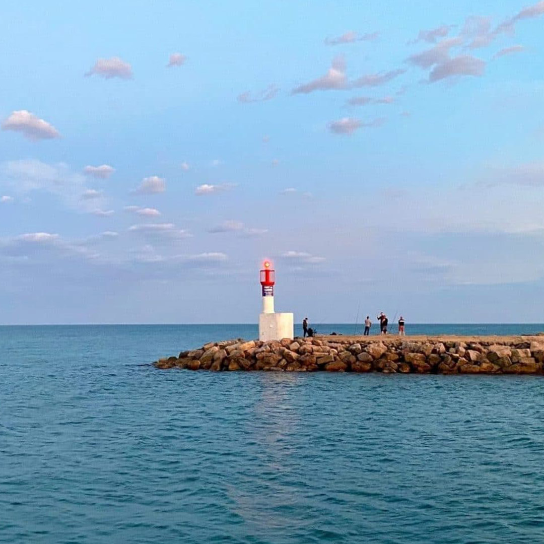 Vue sur la digue du port avec le phare bâbord, restaurant Carnon, le Yacht Café.